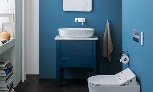 Ein kleines Badezimmer mit einem blauem Waschbecken, einem WC und Dekoration